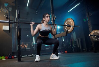 A women training with weights withe the flexible womens active wear collection of ROI & REINE.